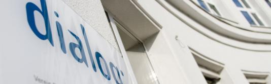 Schild mit Logo des Verein Dialog an einem Gebäude