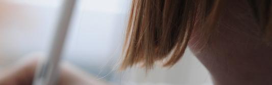 Detailaufnahme eines schreibenden Mädchens von hinten