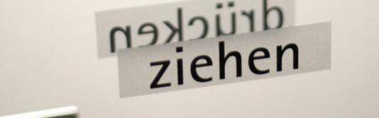 Quelle: photocase.com | C/L http://www.photocase.de/foto/177306-stock-photo-blau-weiss-kalt-wand-grau-mauer Glastüre mit einem Aufkleber mit dem Schriftzug Ziehen