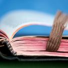 Quelle: Gerti G. | photocase.com http://www.photocase.de/foto/88735-stock-photo-weiss-blau-rot-hell-braun-zusammensein Altes buch liegt aufgeschlagen vor blauem Hintergrund