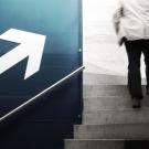 Quelle: photocase.com | krockenmitte http://www.photocase.de/foto/94108-stock-photo-mann-arbeit-erwerbstaetigkeit-business-gehen-erfolg-beton Mann geht Treppen hinauf neben einer Wand mit einem aufgemalten Aufwärtspfeil