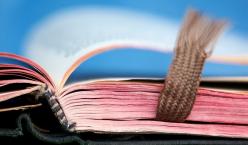 Quelle: Gerti G. | photocase.com http://www.photocase.de/foto/88735-stock-photo-weiss-blau-rot-hell-braun-zusammensein Altes buch liegt aufgeschlagen vor blauem Hintergrund