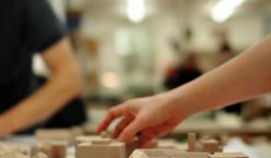 Hand versetzt Holzklotz auf einem Tisch in einer Werkstatt