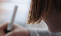 Detailaufnahme eines schreibenden Mädchens von hinten