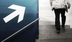 Quelle: photocase.com | krockenmitte http://www.photocase.de/foto/94108-stock-photo-mann-arbeit-erwerbstaetigkeit-business-gehen-erfolg-beton Mann geht Treppen hinauf neben einer Wand mit einem aufgemalten Aufwärtspfeil