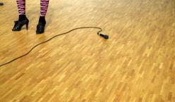 Beine auf Bühne mit frei am Boden liegenden Mikrofon