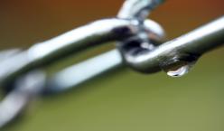 Quelle: sör alex | photocase.com http://www.photocase.de/foto/234859-stock-photo-gruen-kalt-zusammensein-kraft-metall-nass Glänzende Metallkette vor braunem und grünen Hintergrund