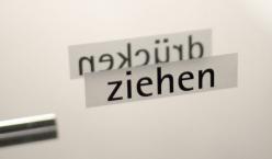 Glastüre mit einem Aufkleber mit dem Schriftzug Ziehen 