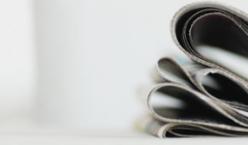 Zeitungen liegen auf einem weißen Sofa